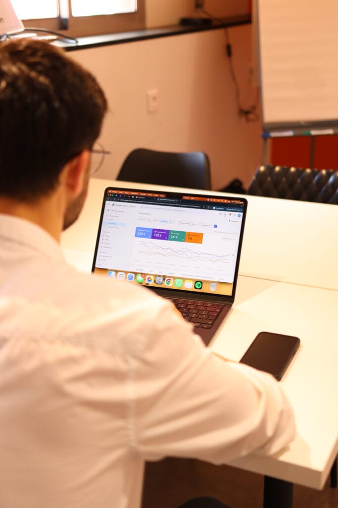 Visuel sur Gabin rafaillac de dos, son ordinateur ouvert montrant des graphiques et courbes d'analyse SEO.